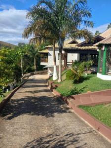 a road leading to a house with palm trees at Casa ampla e completa para você e sua família in Soledade de Minas