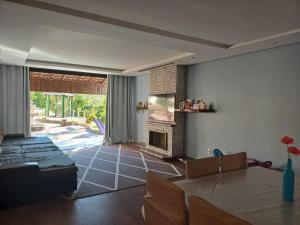 a living room with a table and a fireplace at Casa ampla e completa para você e sua família in Soledade de Minas