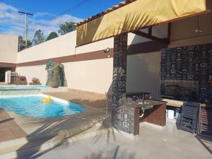 a patio with a swimming pool and an umbrella at Casa ampla e completa para você e sua família in Soledade de Minas +12 photos