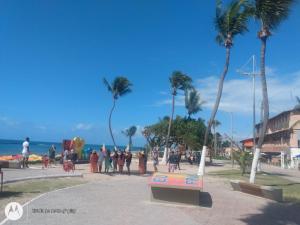 a group of people walking on a sidewalk near the beach at Varanda encontro do mar in Marechal Deodoro