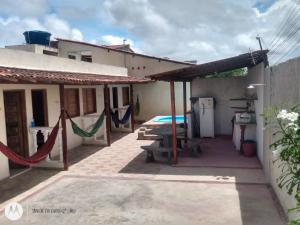 a house with a hammock outside of it at Varanda encontro do mar in Marechal Deodoro
