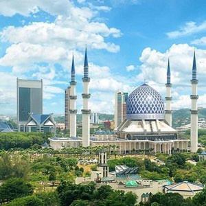 a large mosque with domes and buildings in a city at QH Guesthouse in Shah Alam