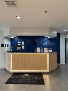 a lobby with a reception desk and a blue wall at Microtel Inn and Suites Baton Rouge Airport in Baton Rouge +50 photos