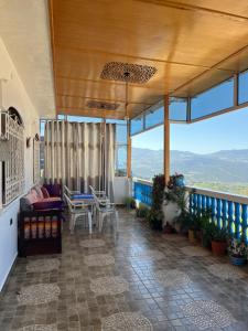 a porch with a couch and chairs on a balcony at Dar RADI Appart Terrace in Chefchaouen