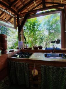 a kitchen with a sink and a window at Pátio FlorAção in Igatu