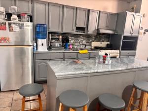 a kitchen with white cabinets and a counter with stools at Casa amplia in Ciudad Juárez