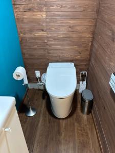 a toilet in a bathroom with a wooden wall at Private Stay HANARE in Shishikui +7 photos