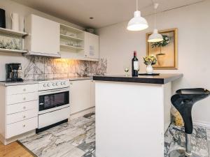 a kitchen with white cabinets and a counter top at Holiday home in Marstal in Brovst +10 photos
