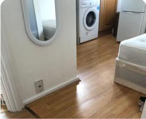 a laundry room with a mirror and a washing machine at Self-contained Studio near Tottenham Hotspurs stadium in London