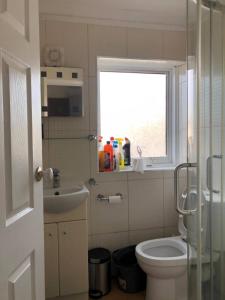 a bathroom with a toilet and a sink and a window at Self-contained Studio near Tottenham Hotspurs stadium in London