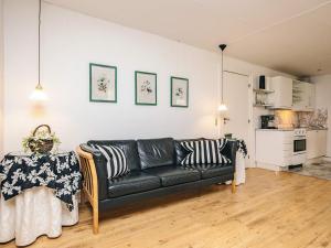 a living room with a black couch and a kitchen at Holiday home in Marstal in Brovst