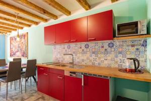 a kitchen with red cabinets and a table with chairs at Mexican-themed holiday homes in Debina +20 photos