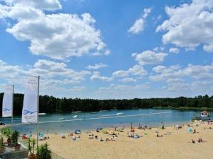 a group of people on a beach next to a river at Bernsteinsee Home and Ferien Forest Chalet in Sassenburg
