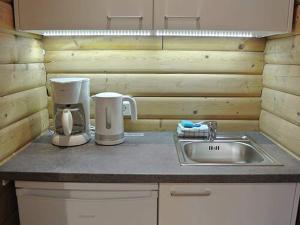 a kitchen counter with a sink and a coffee maker at Bernsteinsee Home and Ferien Forest Chalet in Sassenburg