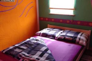 a small bed in a room with green and orange at Mexican-style holiday homes in Debina