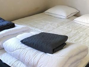 a large white bed with a black pillow on it at Charming Red Farmhouse Near Forsheda in Krokom +29 photos