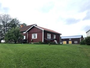 a red house with a large green yard at Charming Red Farmhouse Near Forsheda in Krokom