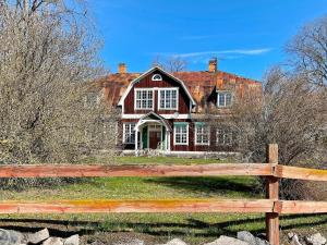 a large red house behind a wooden fence at 9 person holiday home in Mörlunda-By Traum in Mörlunda