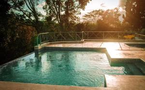 a large pool of water with the sun shining at Acogedorapartamento entre montañas in Pedro Brand