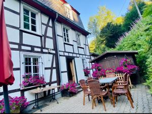 a house with a table and chairs in front of it at Historisches Fachwerk Haus am Fluss in Monschau