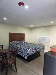 a bedroom with a bed and a table and a bed and a room at James Motel in Saugus