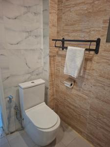 a bathroom with a white toilet and a towel at Hôtel Résidence Ngary in Thiès +22 photos