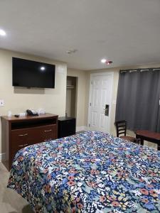 a bedroom with a bed and a tv on the wall at James Motel in Saugus