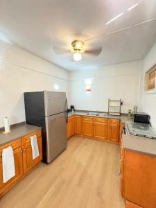 a kitchen with a stainless steel refrigerator and wooden cabinets at Cocoon apartment with garden, quiet in Simpson Bay