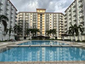 a large apartment building with a large swimming pool at SMDC Field REsidences condo unit in Manila