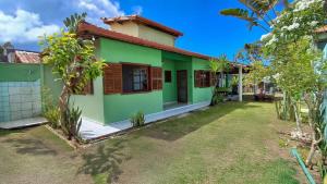 a green and white house with a yard at BEACH HOUSE pé na areia in Santa Cruz Cabrália +13 photos