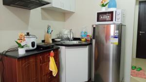 a kitchen with a stainless steel refrigerator and a sink at B4B Staycation Avida Aspira in Cagayan de Oro +6 photos