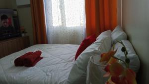 a bed with two red mittens on it with a window at B4B Staycation Avida Aspira in Cagayan de Oro