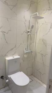 a white bathroom with a toilet and a shower at فندق العجمي 100 in 6th Of October +9 photos