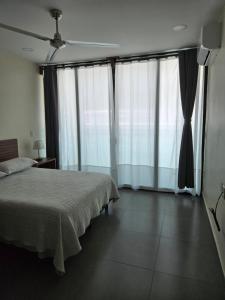 a bedroom with a bed and two large windows at Departamento Huatulco 1 Torre Bel in Santa Cruz Huatulco