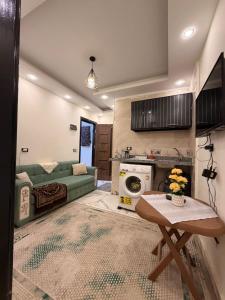 a living room with a green couch and a table at فندق العجمي 100 in 6th Of October