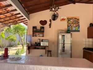a kitchen with a refrigerator and a table at BEACH HOUSE pé na areia in Santa Cruz Cabrália