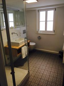 a bathroom with a sink, toilet, and bathtub at Brauereigasthof Krone Öhringen in Öhringen