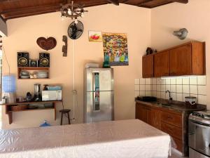 a kitchen with a stainless steel refrigerator and wooden cabinets at BEACH HOUSE pé na areia in Santa Cruz Cabrália