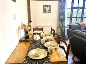 a table with plates and cups on it in a living room at Jemima's Cottage in Bassenthwaite