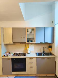 a kitchen with a sink and a stove top oven at Old Town Apartment with Terrace - Live Love Lake in Peschiera del Garda