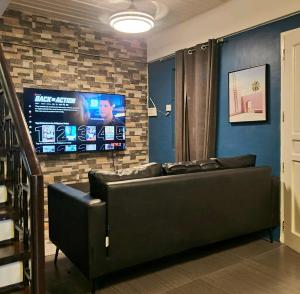 a living room with a couch and a flat screen tv at BCDCrib in Bacolod