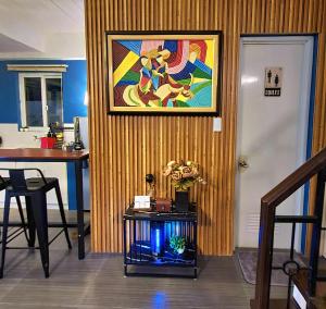 a room with a painting on the wall and a table at BCDCrib in Bacolod
