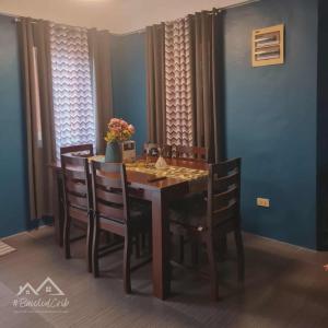 a dining room table and chairs in a room with blue walls at BCDCrib in Bacolod +1 photo