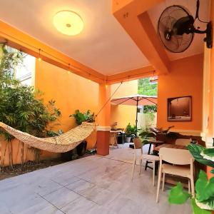 a patio with a hammock and a table and chairs at BCDCrib in Bacolod