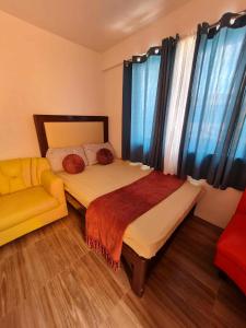 a bedroom with a bed and a couch at BCDCrib in Bacolod