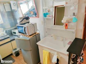 a small kitchen with a sink and a microwave at 别墅之家オーナーChangeAorB in Kami-furano +77 photos