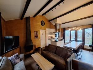 a living room with a couch and a table and a kitchen at Chalet in Manhay for 9 Person in Manhay +24 photos