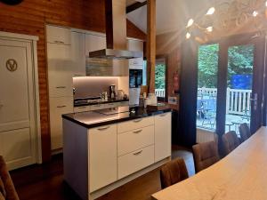 a kitchen with white cabinets and a table with chairs at Chalet in Manhay for 9 Person in Manhay