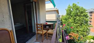 a balcony with a table and chairs and flowers at Altobello Venice Apartment in Mestre