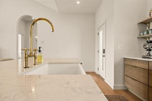 a kitchen with a large sink and a gold faucet at Villa Acadia with Mountain Views in Bar Harbor +58 photos